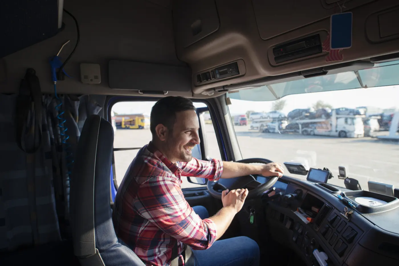 A smiling HGV driver at the wheel of his cab